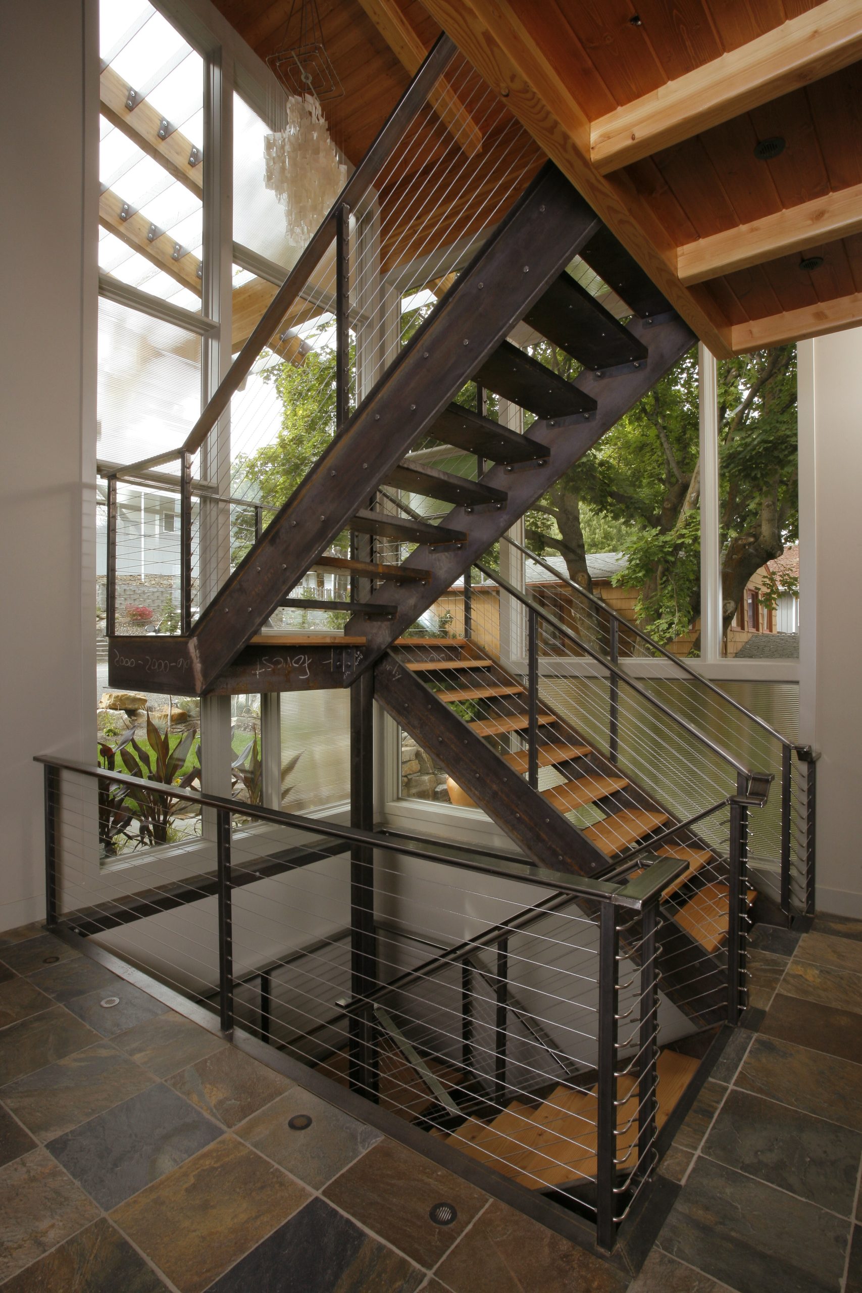 Wood and steel staircase in Liberty Lake home. Travertine flooring
